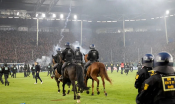 Fans and police injured in pitch invasion during ‘high risk’