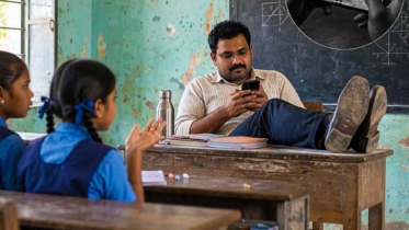 Teacher plays games with feet on table instead of taking class